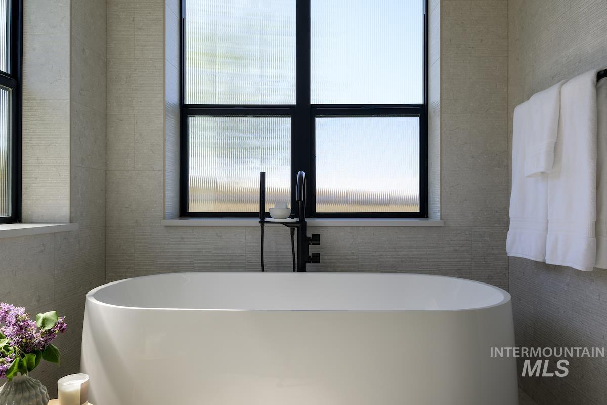Bathroom featuring a freestanding bath and healthy amount of natural light