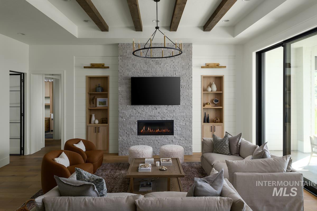 Living room with healthy amount of natural light, beam ceiling, wood finished floors, built in features, and recessed lighting