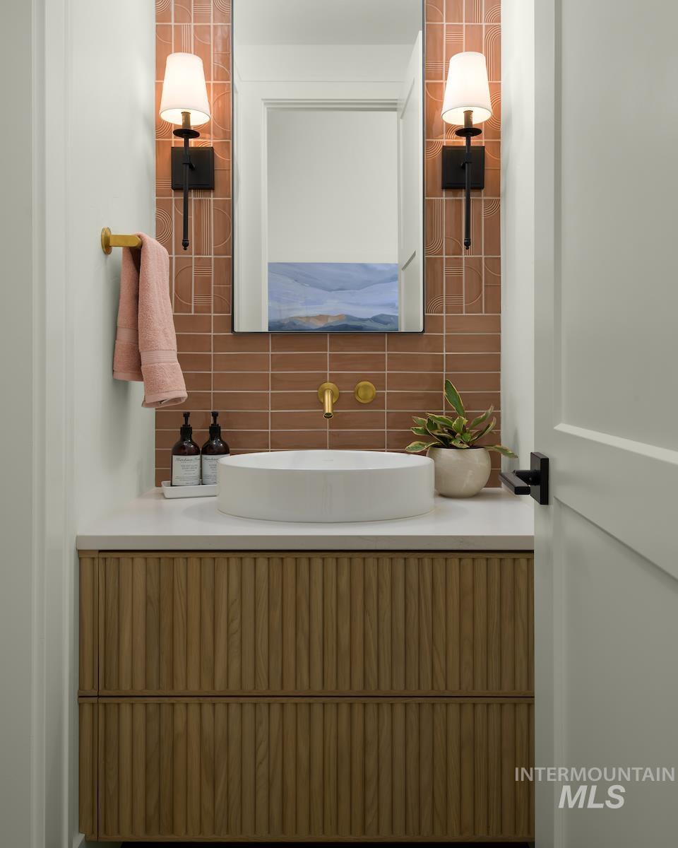 Bathroom with vanity and tasteful backsplash