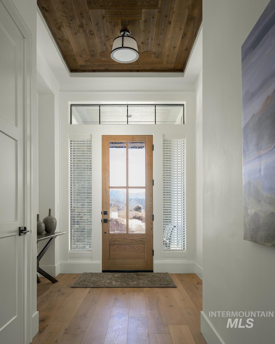 Entrance foyer with baseboards and wood-type flooring