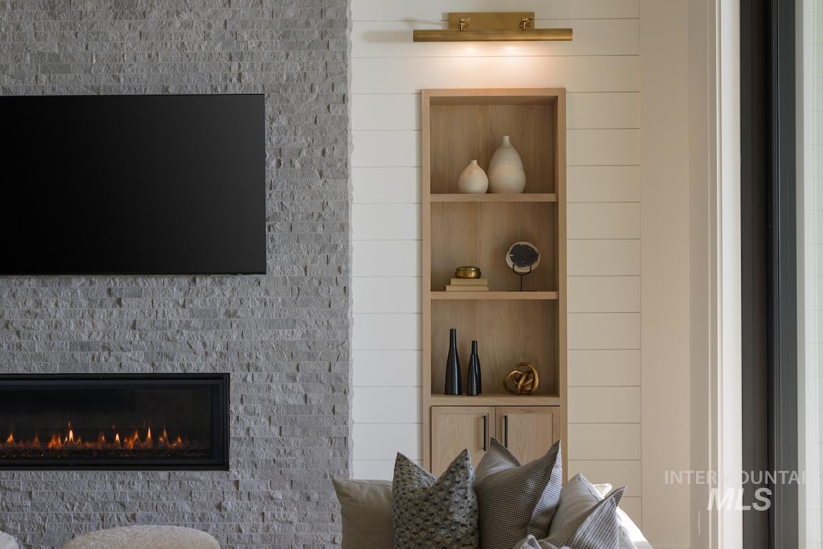 Detailed view of built in shelves and a warm lit fireplace
