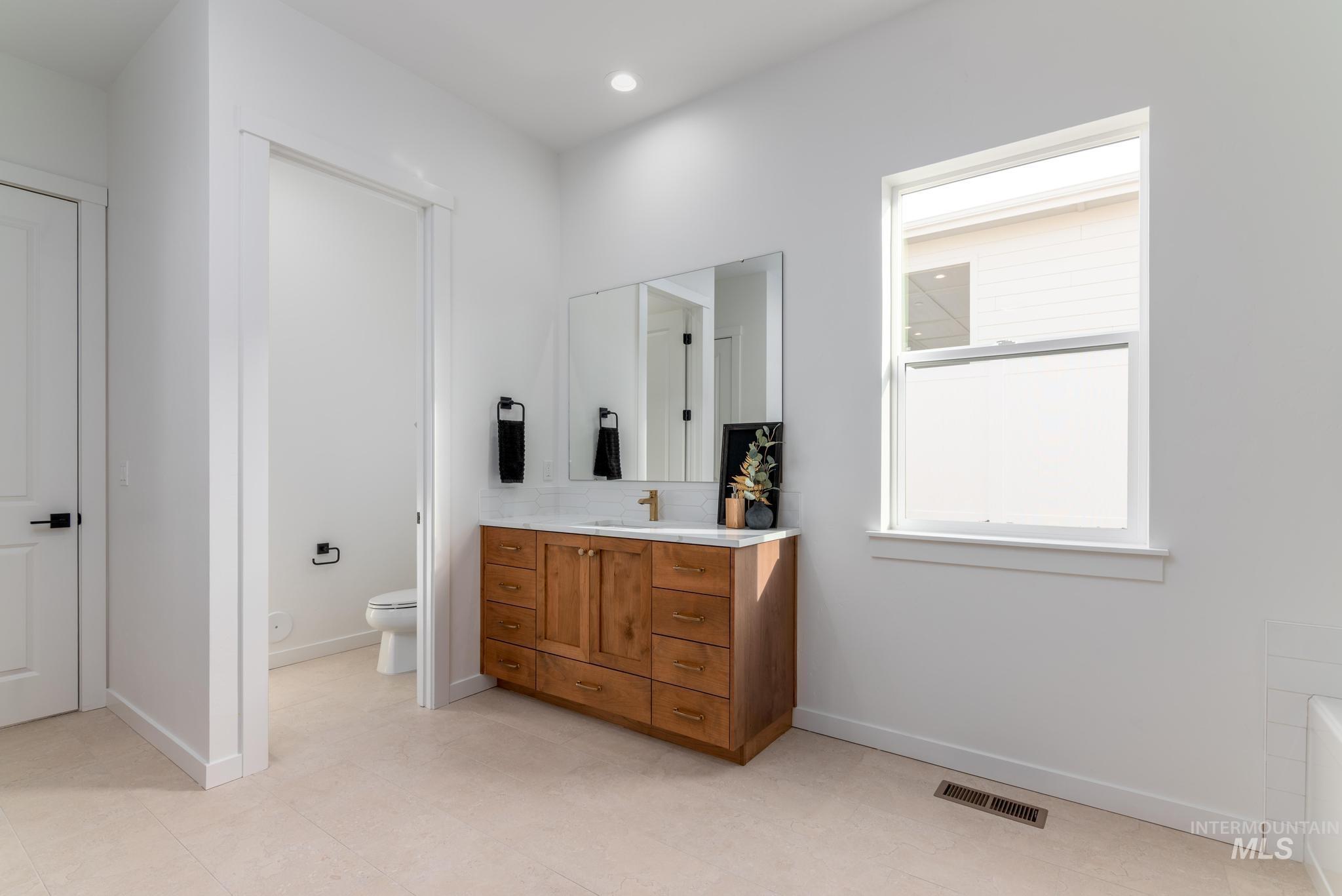 Full bathroom featuring vanity, a tub, and recessed lighting