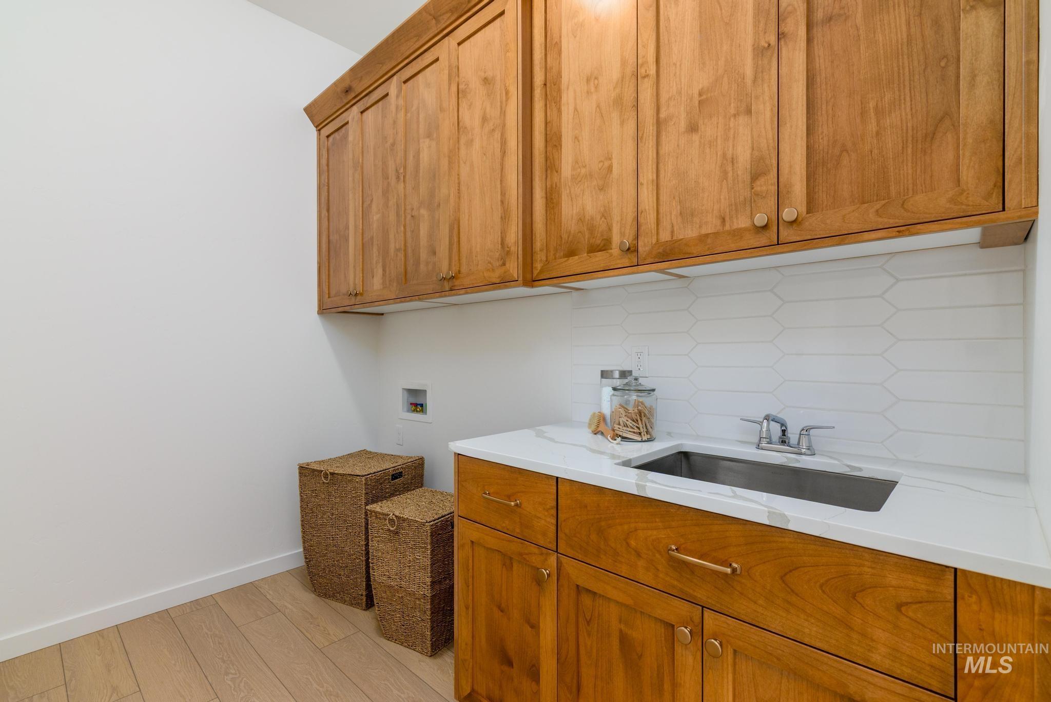 Laundry room with light wood-style floors, cabinet space, and hookup for a washing machine
