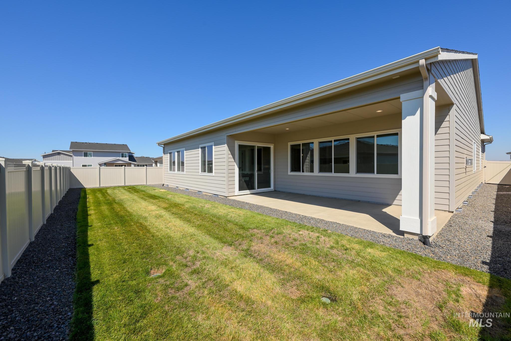 Rear view of house featuring a fenced backyard and a patio area