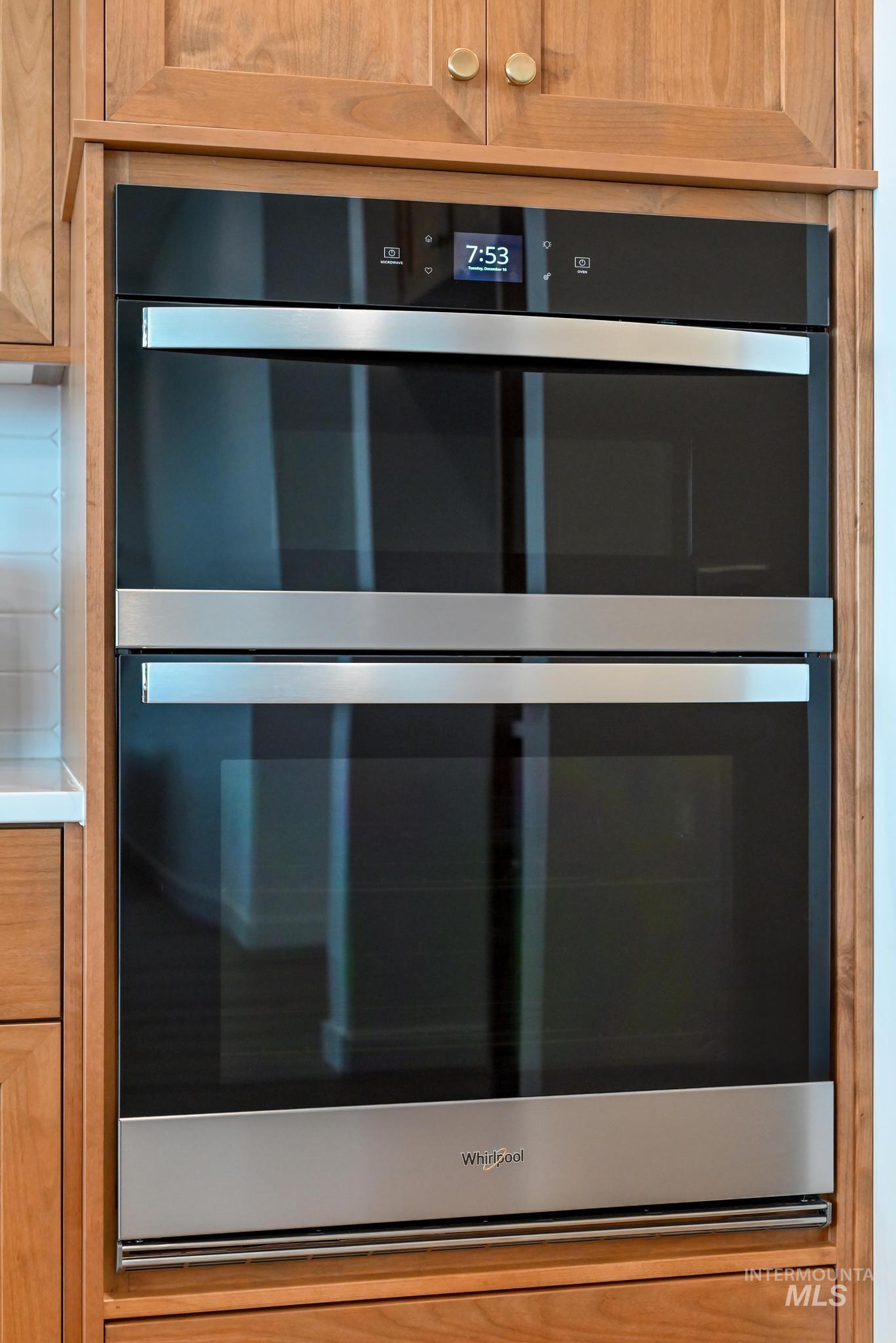 Kitchen view of double oven, brown cabinets, and light countertops