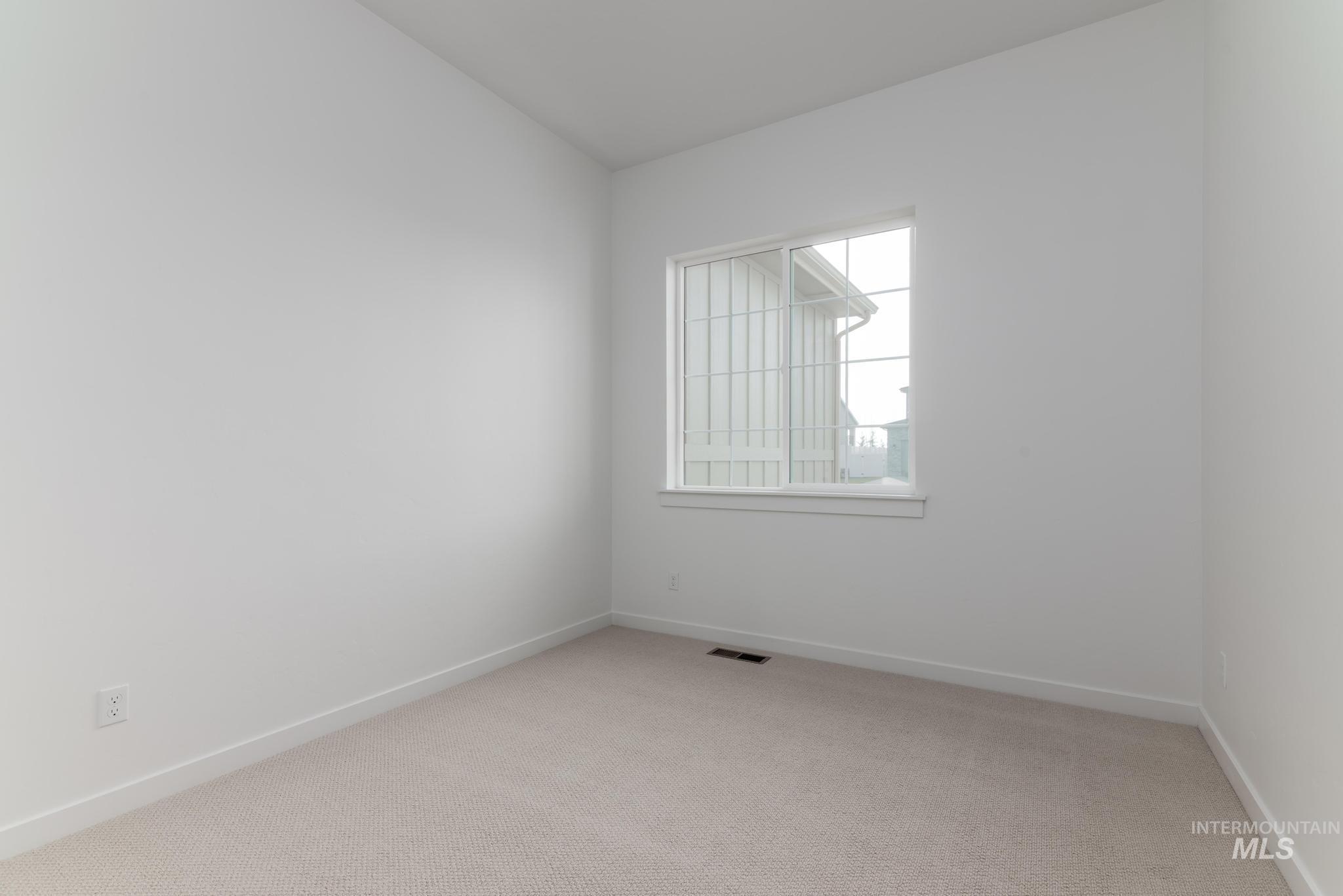 Spare room with light colored carpet and baseboards