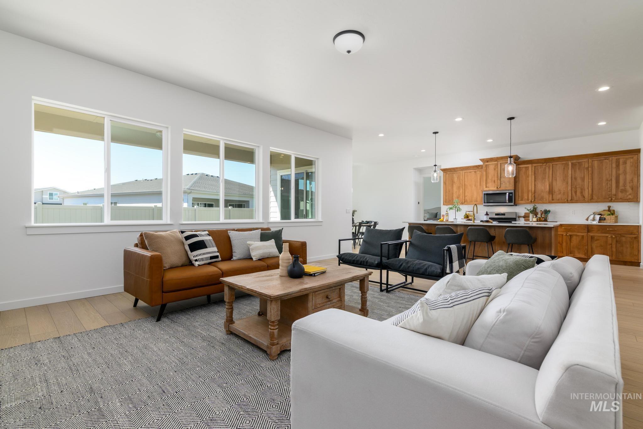 Living area with light wood finished floors and recessed lighting