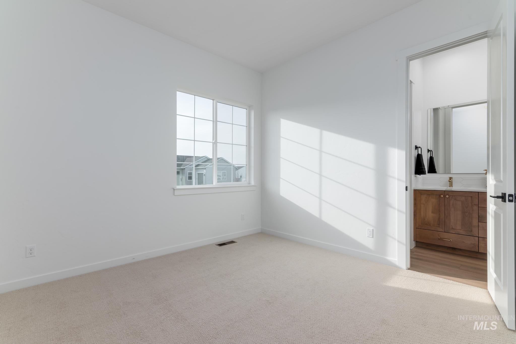 Empty room featuring light carpet and baseboards