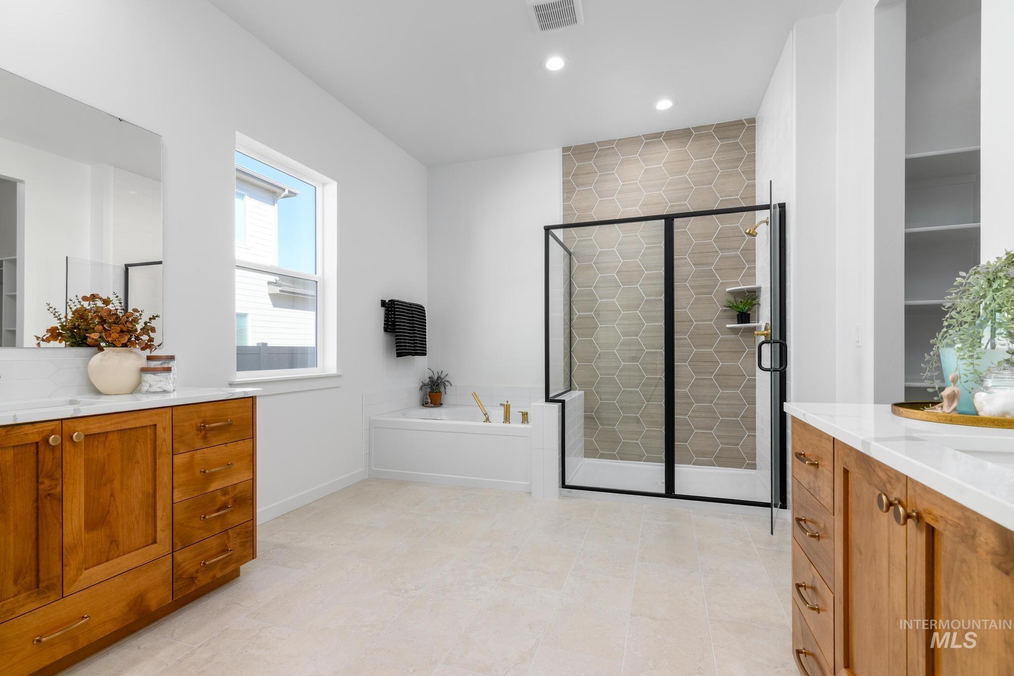 Bathroom featuring vanity, a bath, a shower stall, and recessed lighting