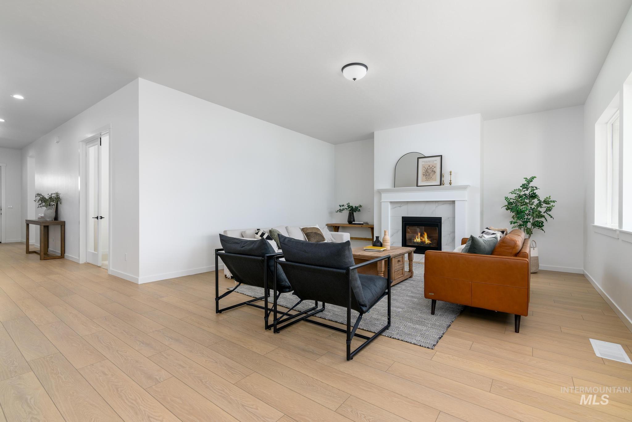 Living area featuring a tile fireplace, light wood-type flooring, and recessed lighting