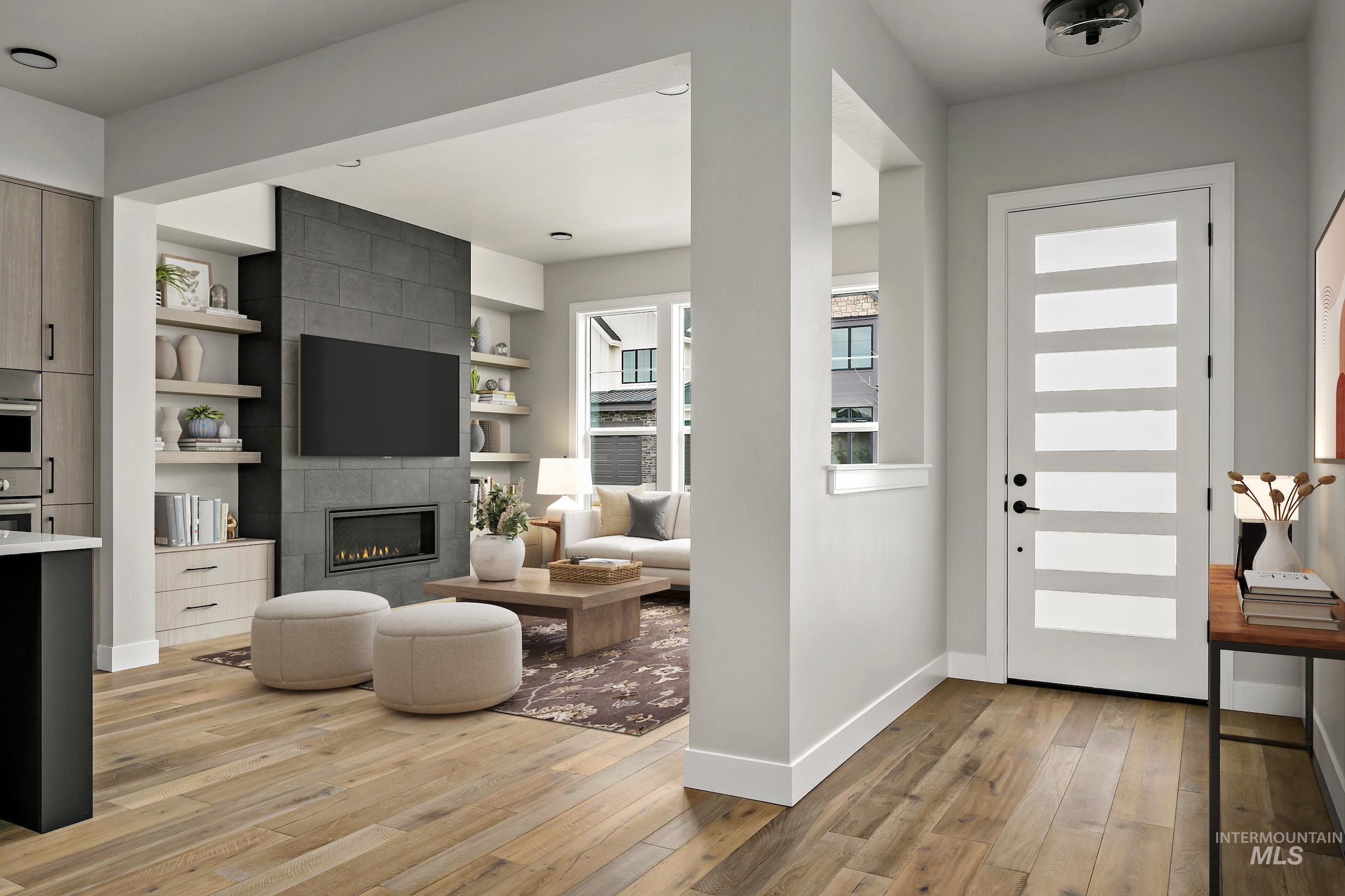 Foyer with a tiled fireplace and light wood finished floors