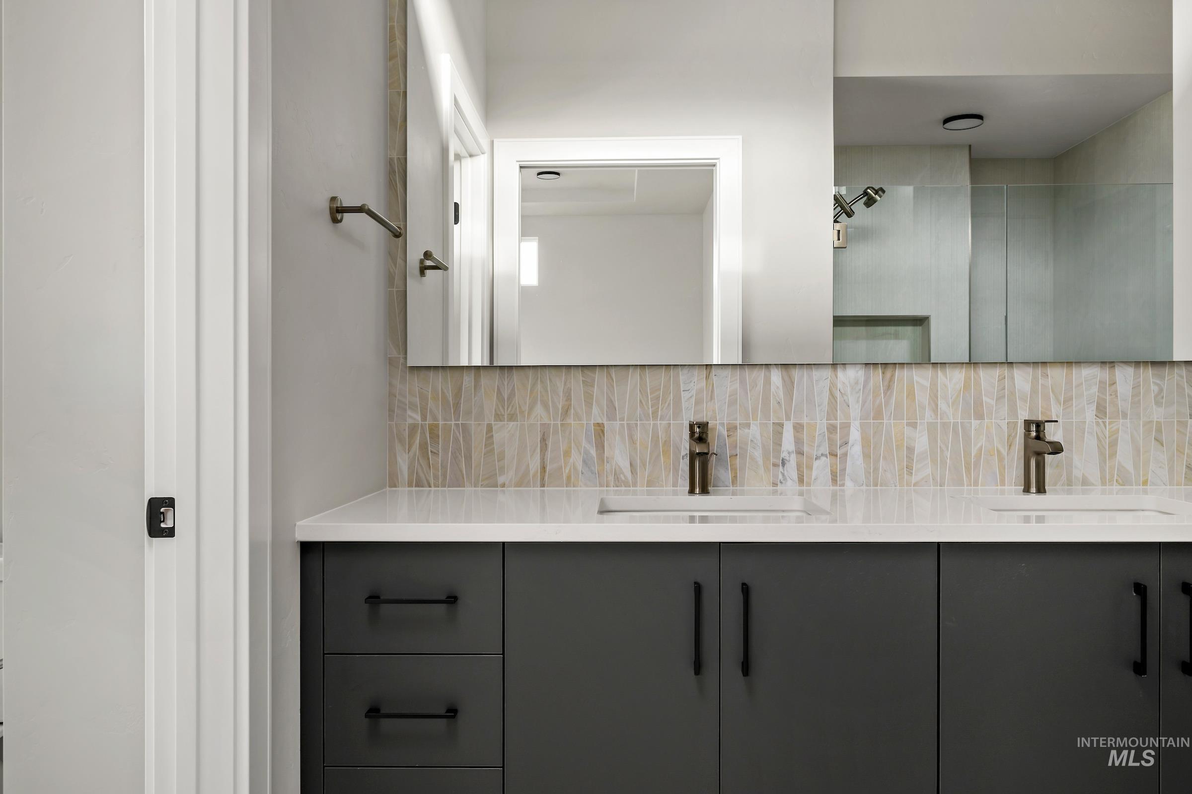 Bathroom with double vanity and tasteful backsplash