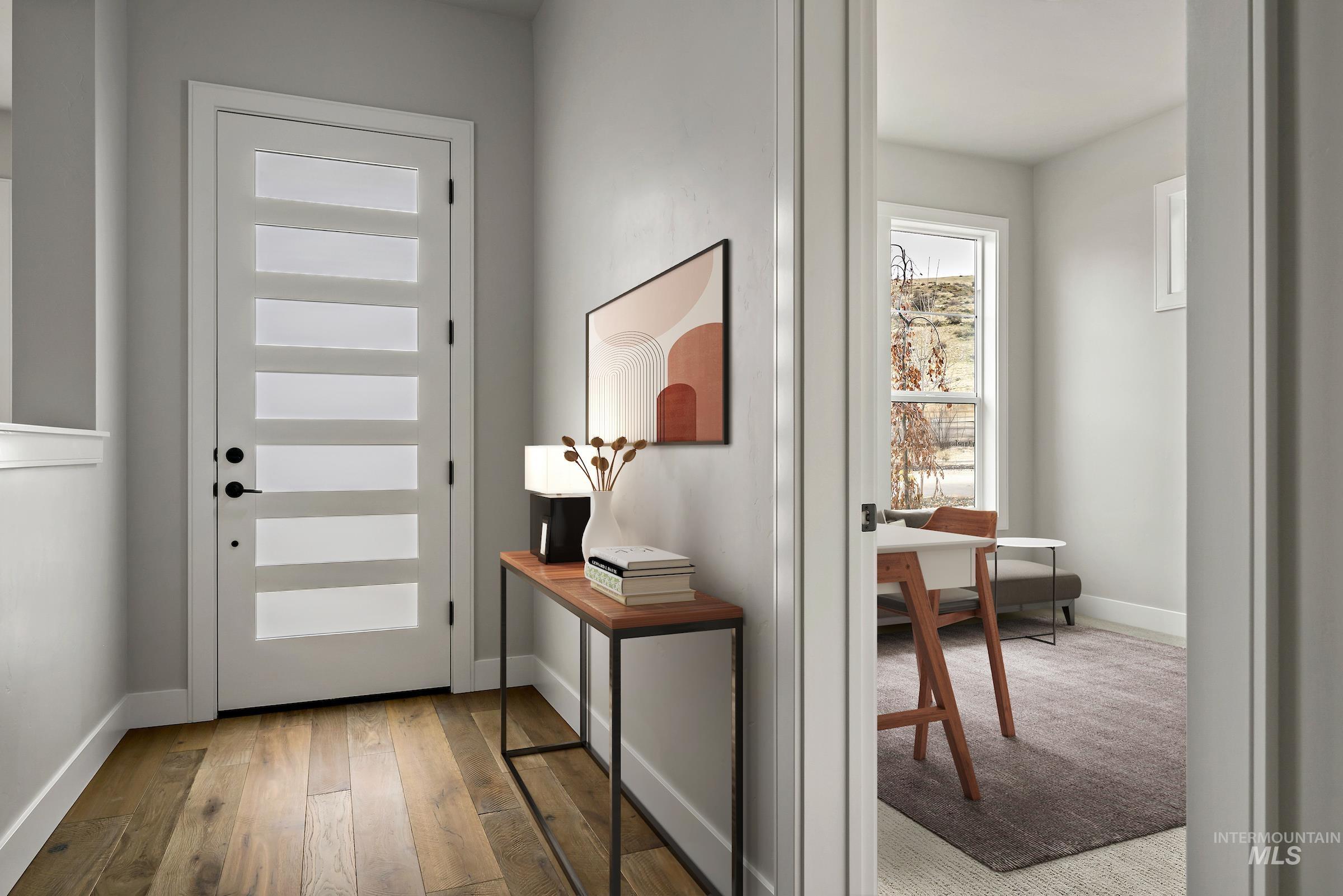 Entryway with hardwood / wood-style flooring and baseboards