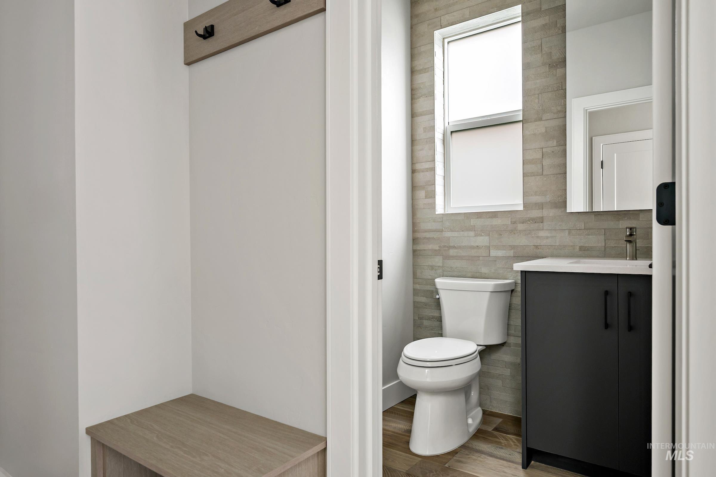 Bathroom featuring vanity, light wood finished floors, and tile walls