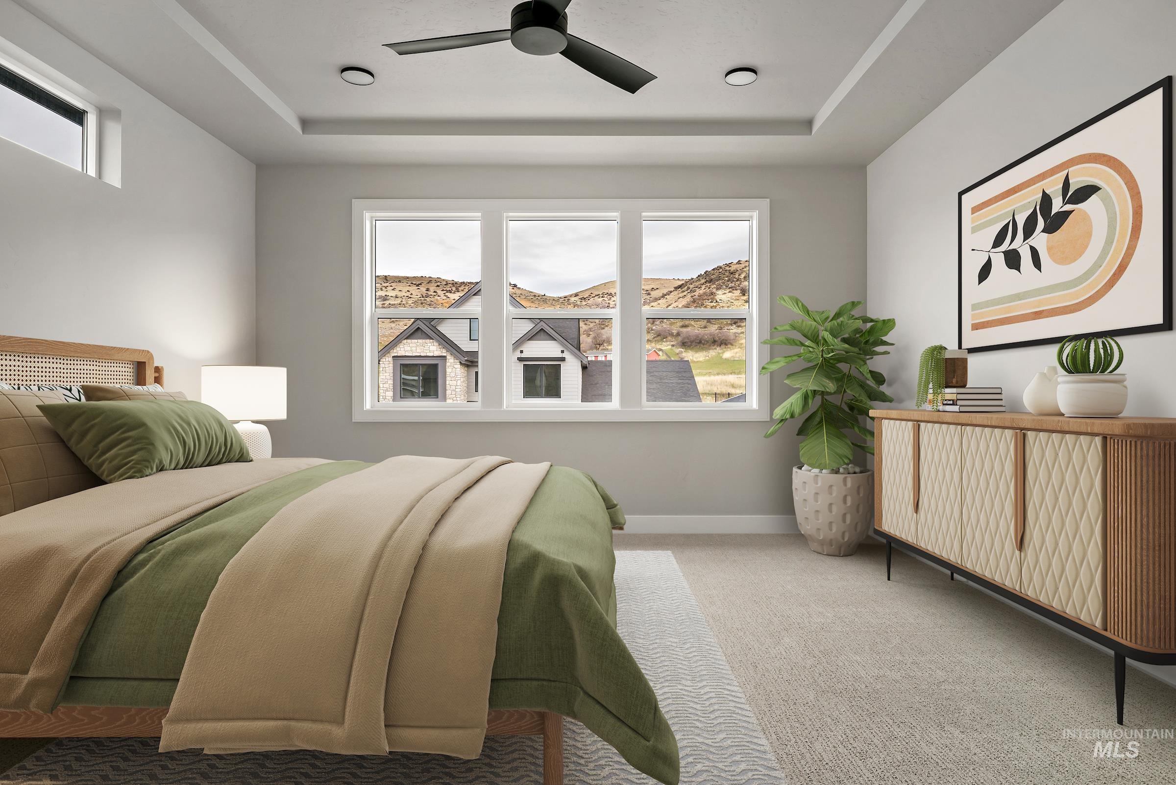 Carpeted bedroom featuring multiple windows, a tray ceiling, and ceiling fan