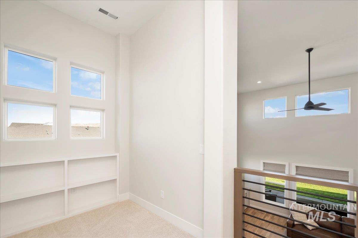 Hall featuring light colored carpet and baseboards