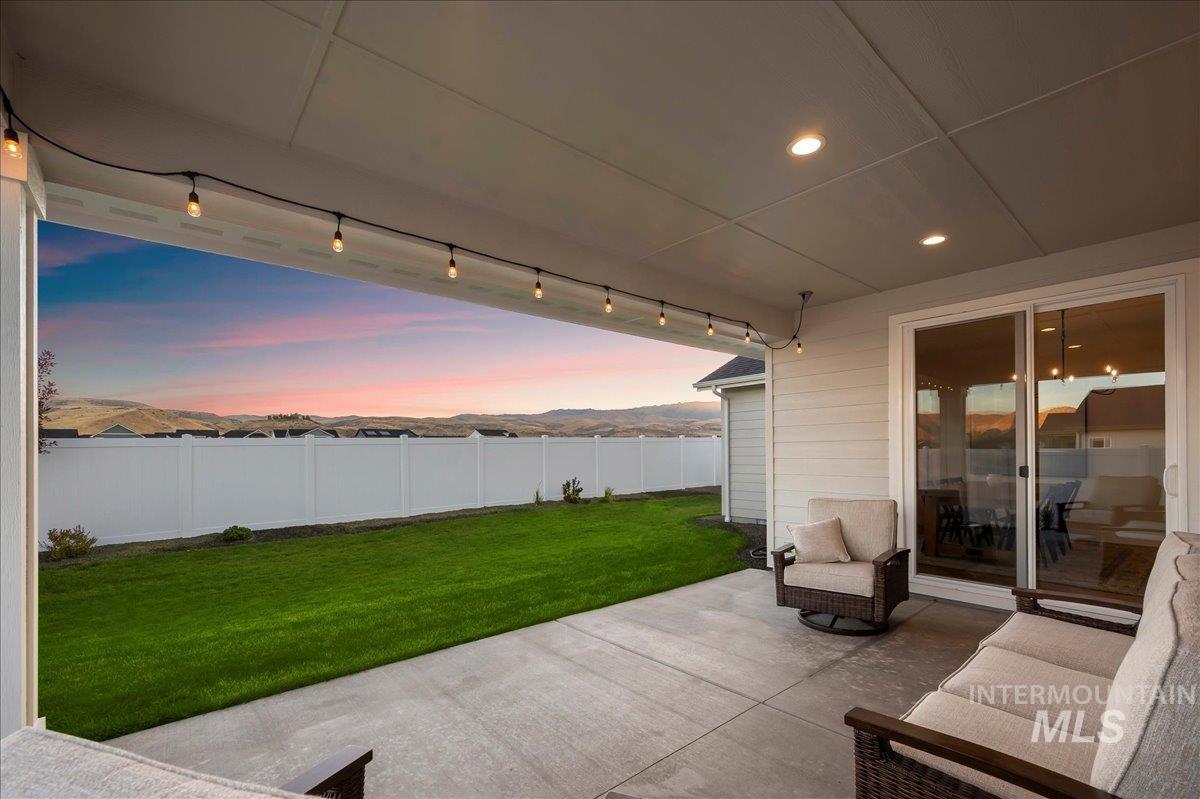 Patio terrace at dusk featuring a fenced backyard and a patio area