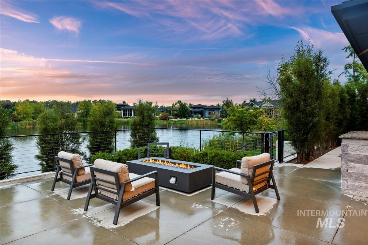 Patio terrace at dusk featuring a water view, an outdoor fire pit, and a patio area