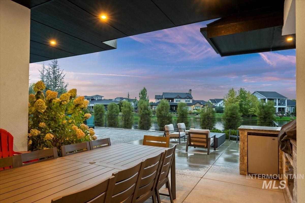 Patio terrace at dusk featuring outdoor dining area, a patio, a grill, a residential view, and an outdoor hangout area