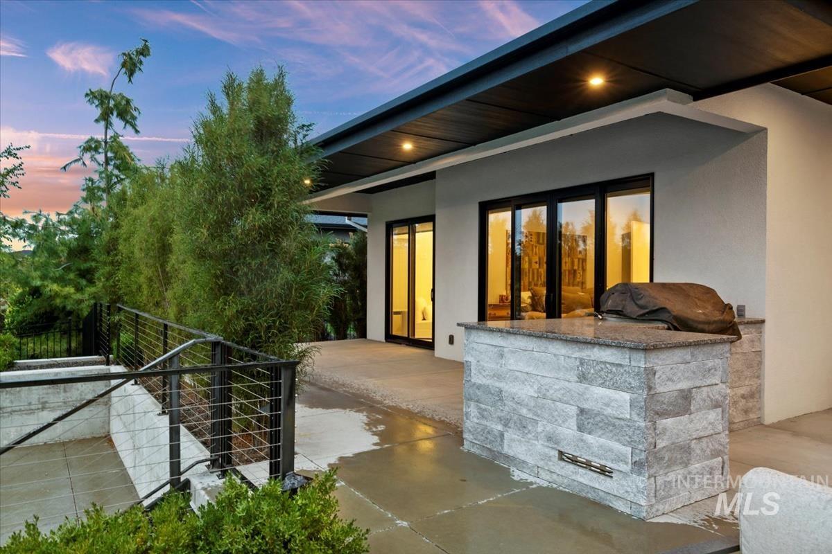 Exterior entry at dusk with stucco siding and a patio area