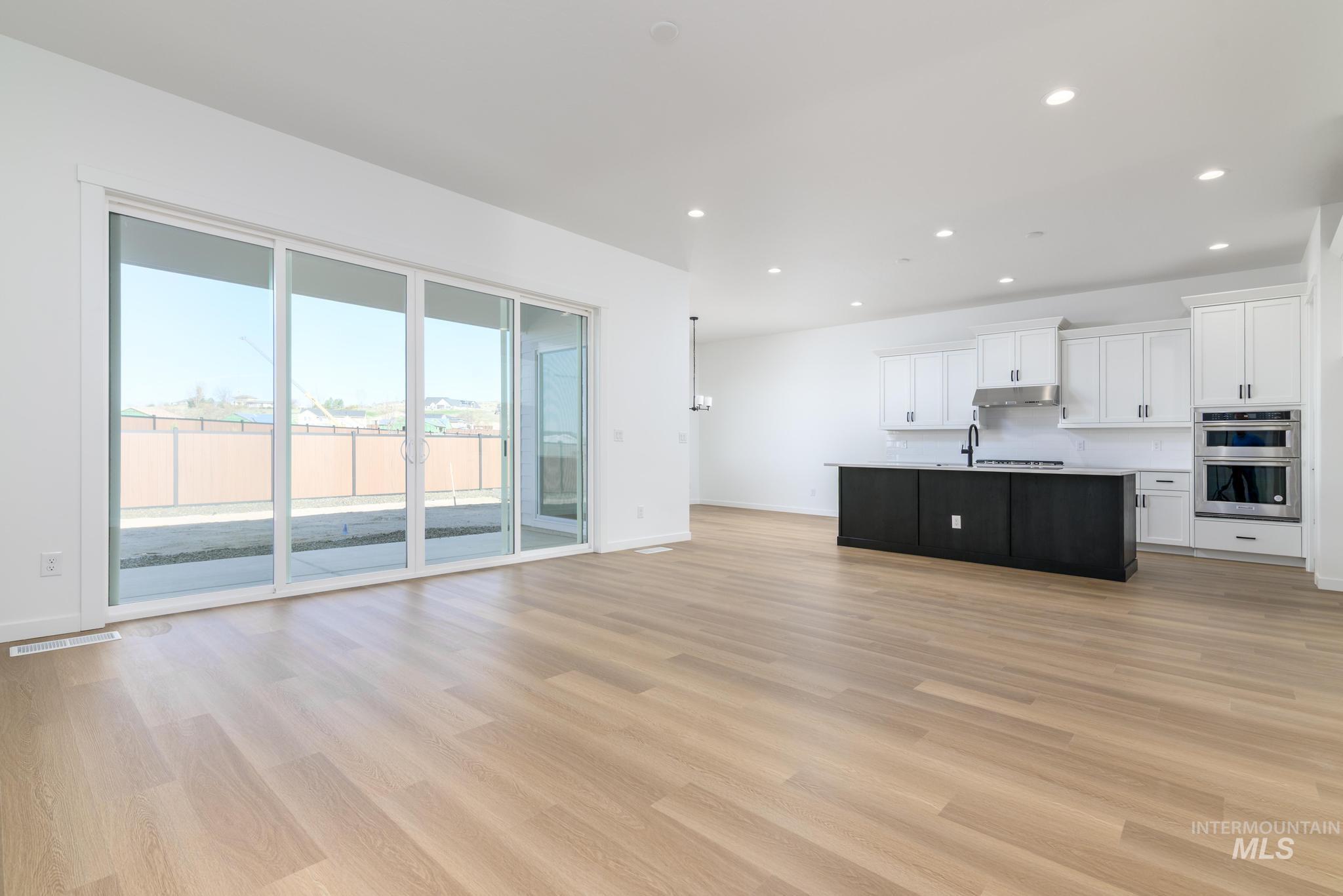 Unfurnished living room with light wood finished floors and recessed lighting