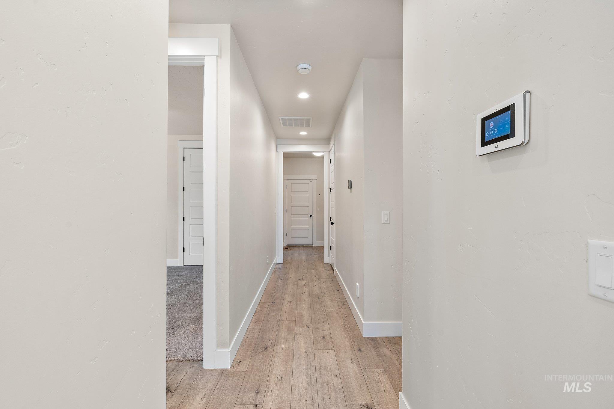 Corridor with recessed lighting and light wood finished floors