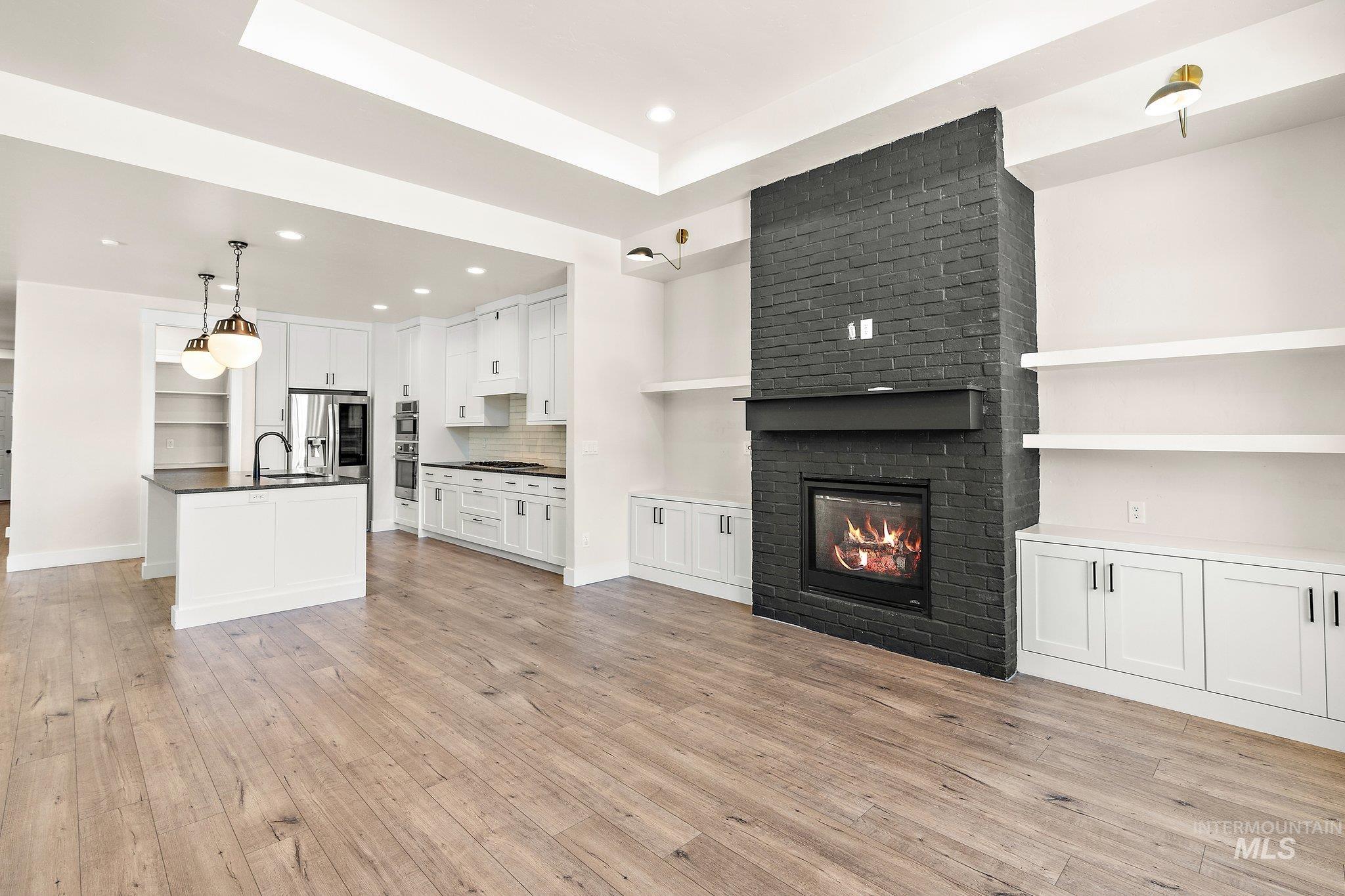 Unfurnished living room with a fireplace, light wood-type flooring, and recessed lighting