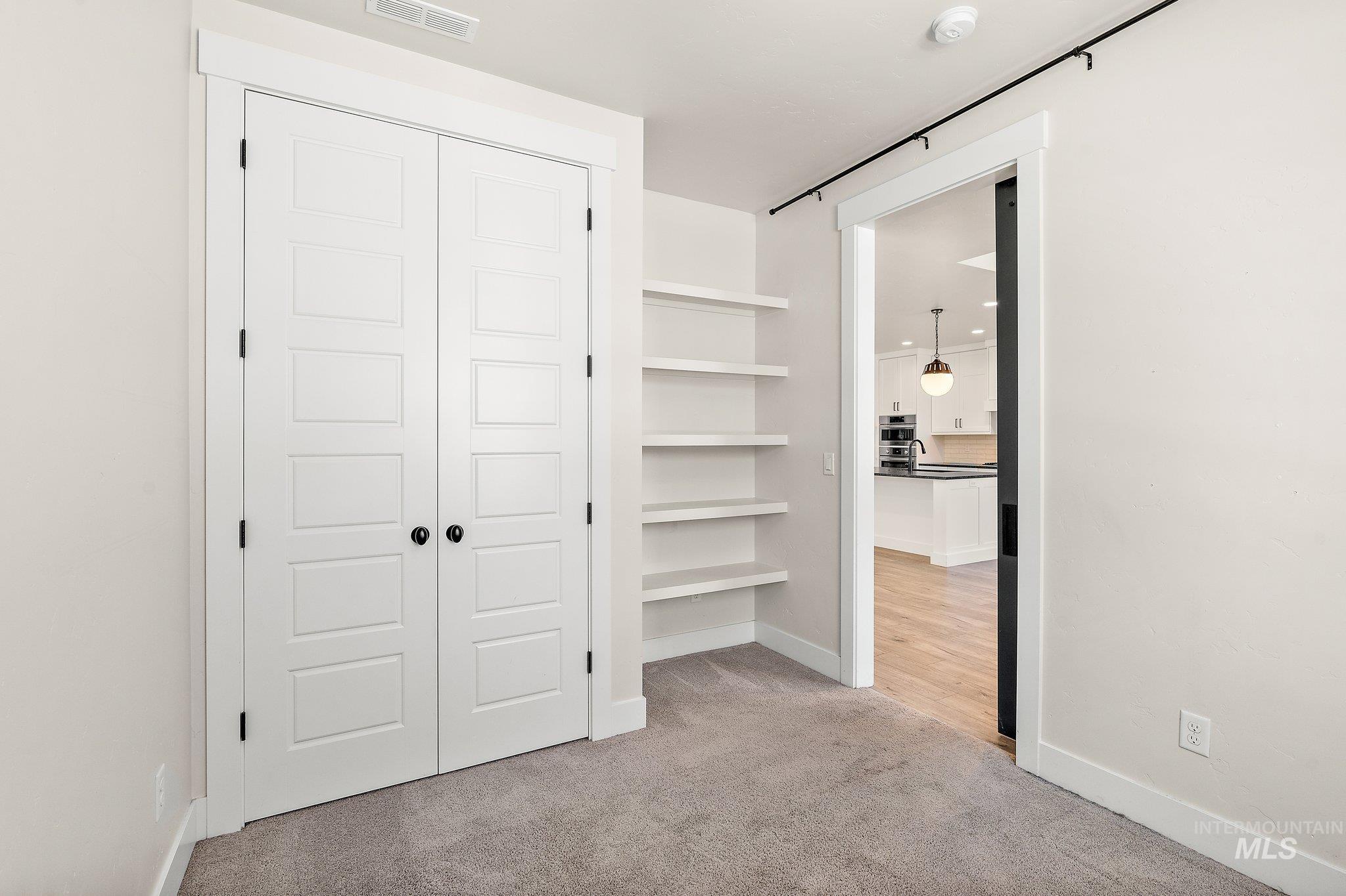 Unfurnished bedroom with light colored carpet and a closet