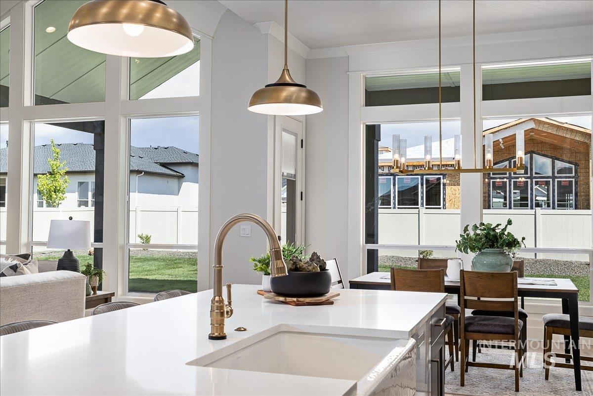 Kitchen with light stone counters and decorative light fixtures