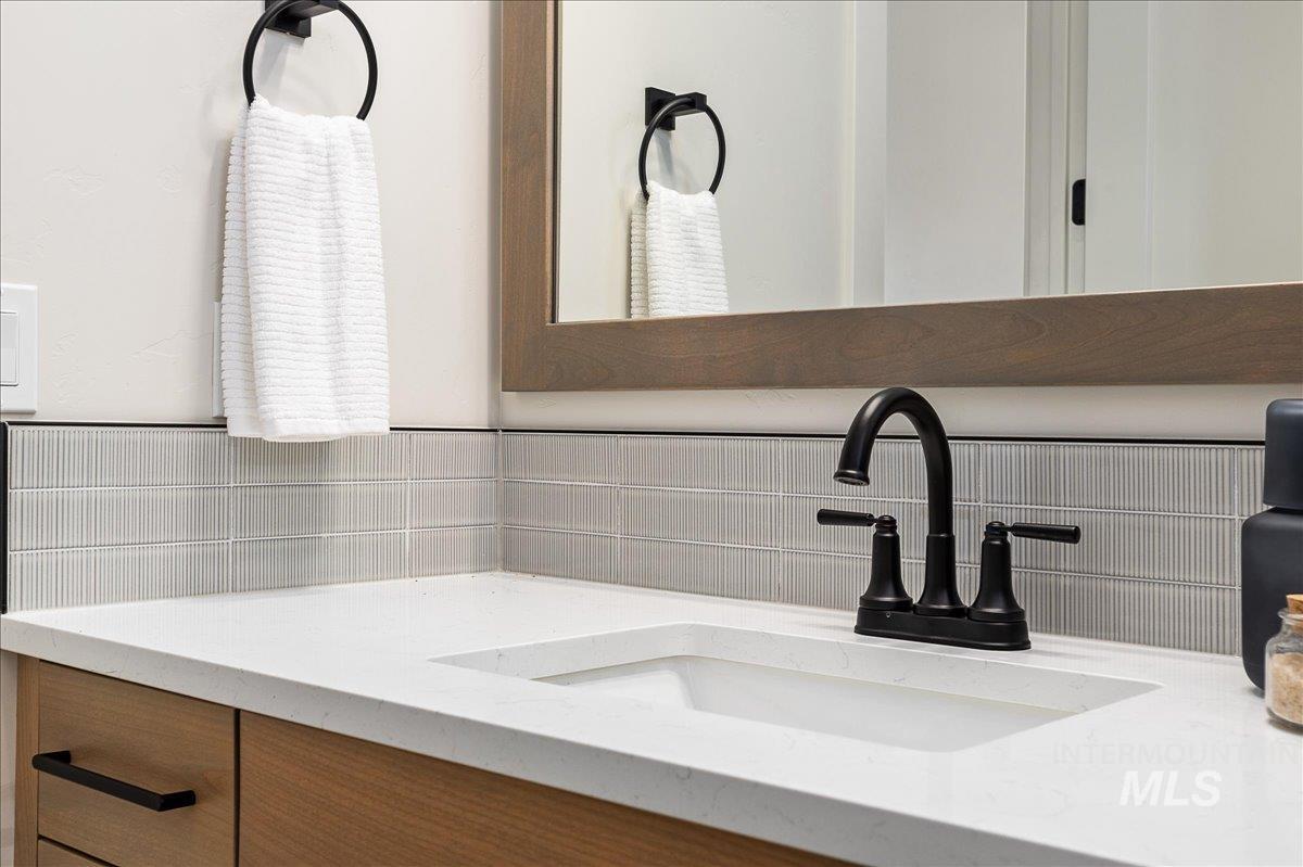 Bathroom view of vanity and tasteful backsplash