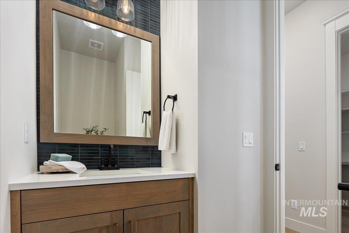 Bathroom with tasteful backsplash and vanity