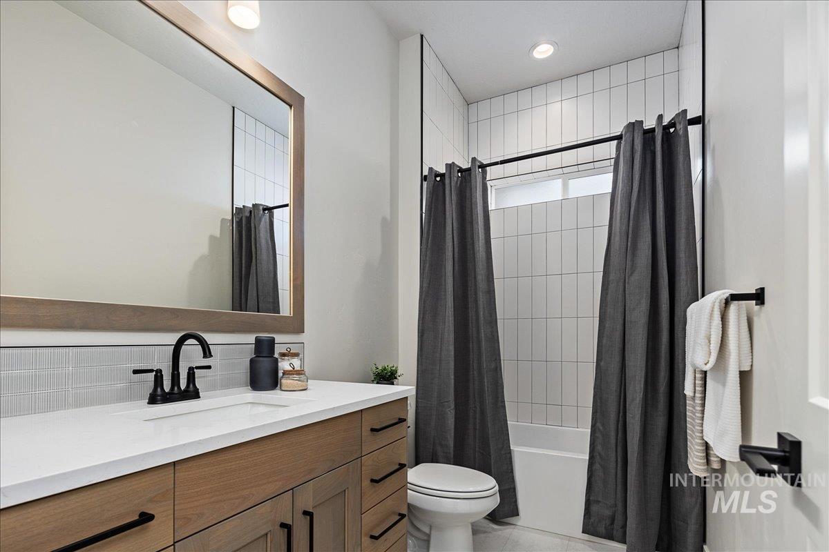Full bath featuring vanity, shower / tub combo, and recessed lighting