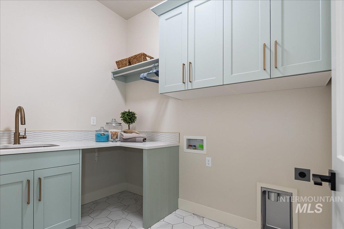 Laundry room with hookup for a washing machine, cabinet space, hookup for an electric dryer, and light tile patterned floors