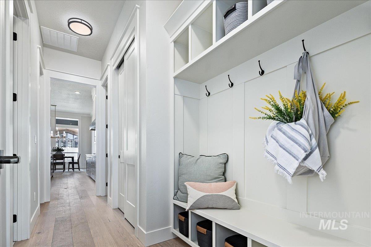 Mudroom featuring light wood finished floors and a textured ceiling