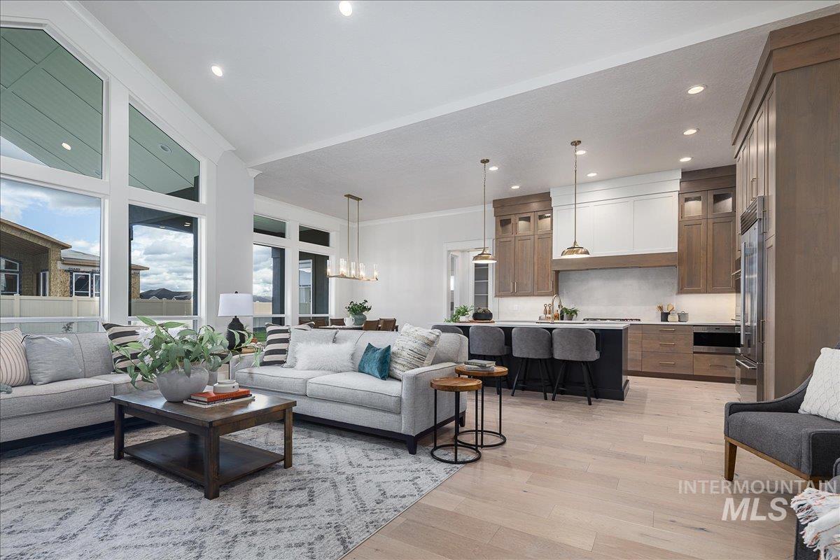 Living area featuring a chandelier, light wood-type flooring, recessed lighting, and ornamental molding