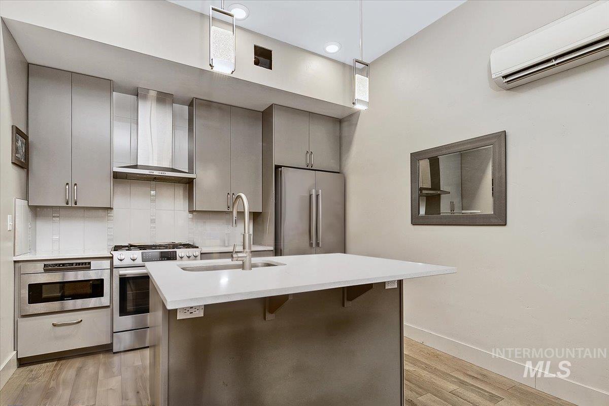 Contemporary kitchen featuring an island with a white countertop and integrated sink