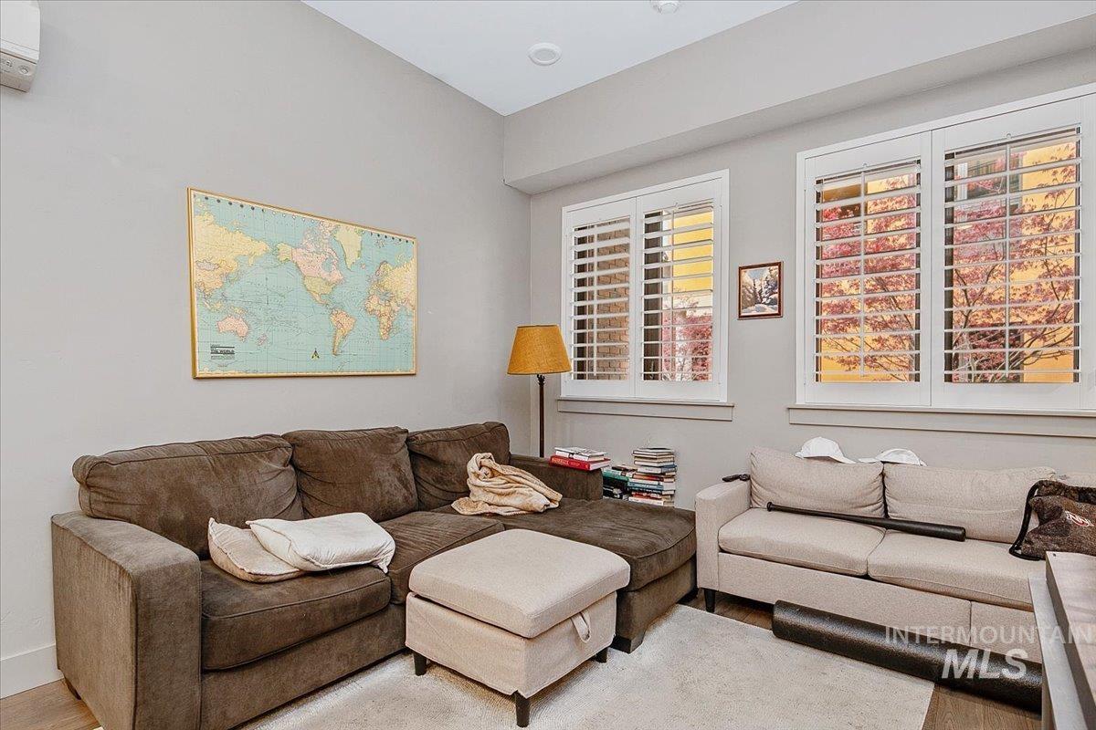 Living room featuring wood finished floors and an AC wall unit