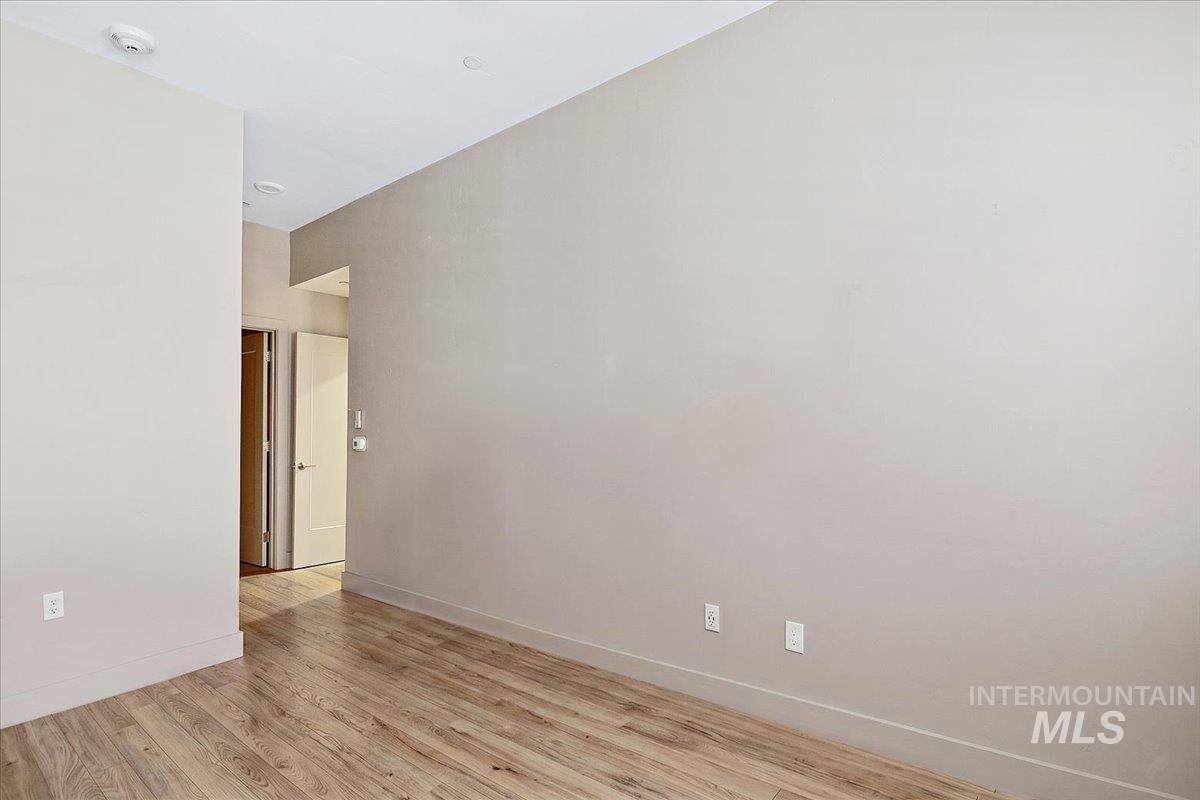 Interior room featuring wood-finish flooring, light neutral wall paint, and recessed ceiling lighting
