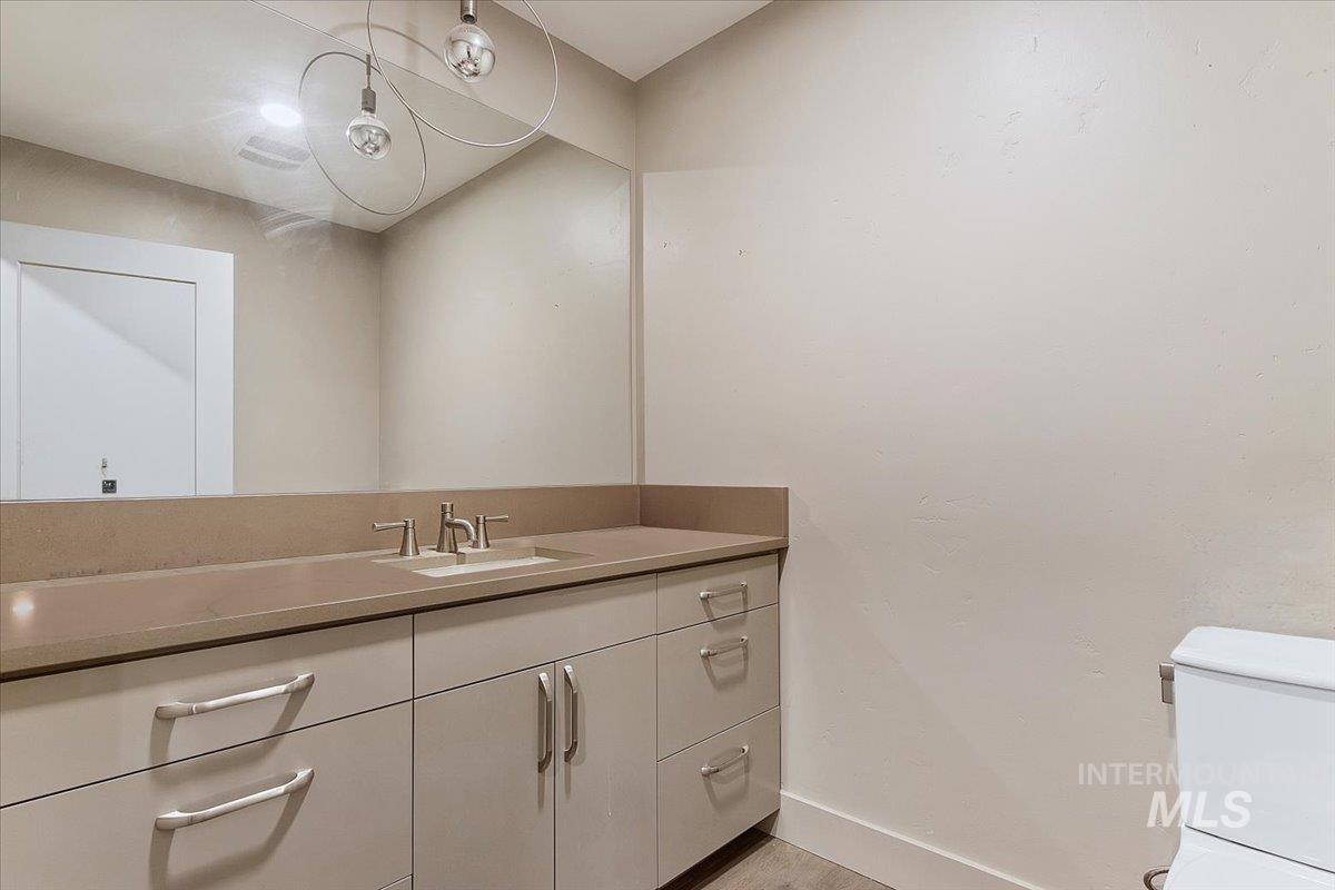 Bathroom vanity with an integrated sink, brushed nickel faucet, and a large wall-mounted mirror