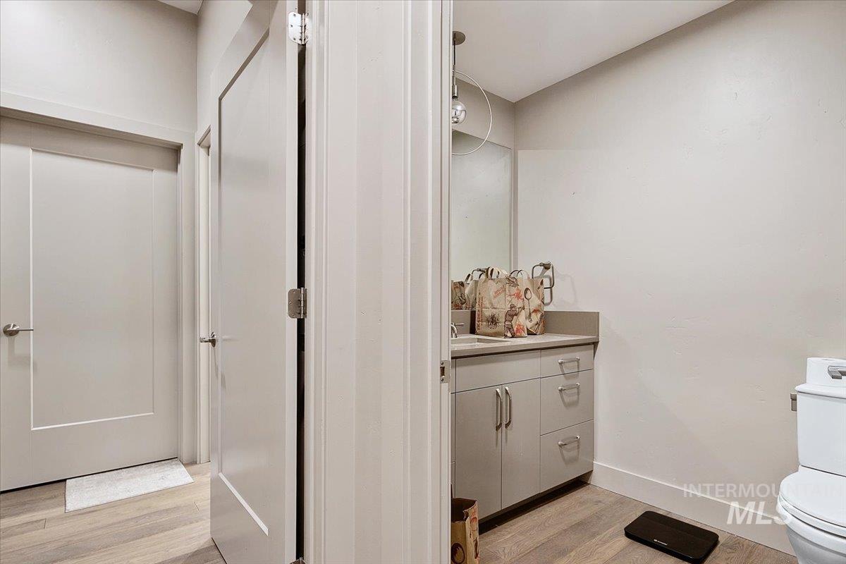 Half bath with light wood-style floors and vanity