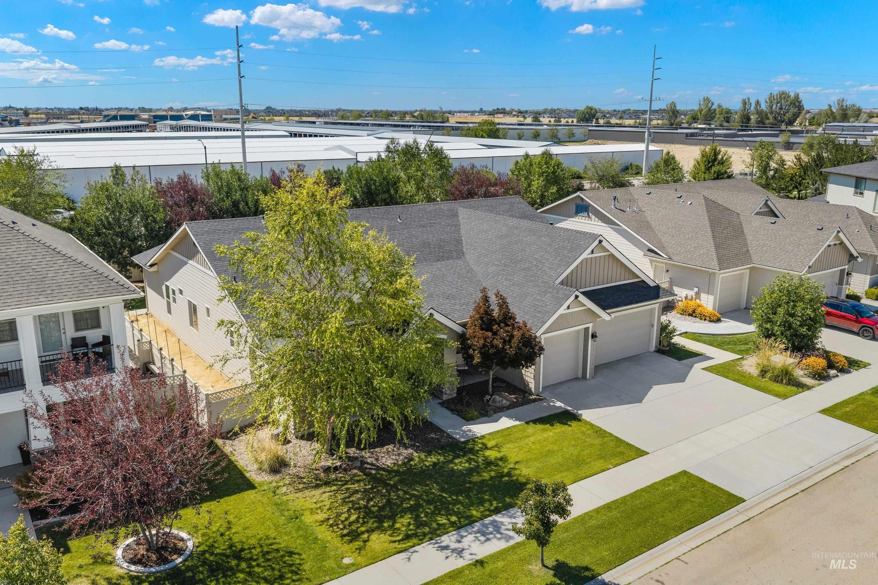Gray siding exterior with dark gray shingles, two-car garage, concrete driveway, and front lawn landscaping
