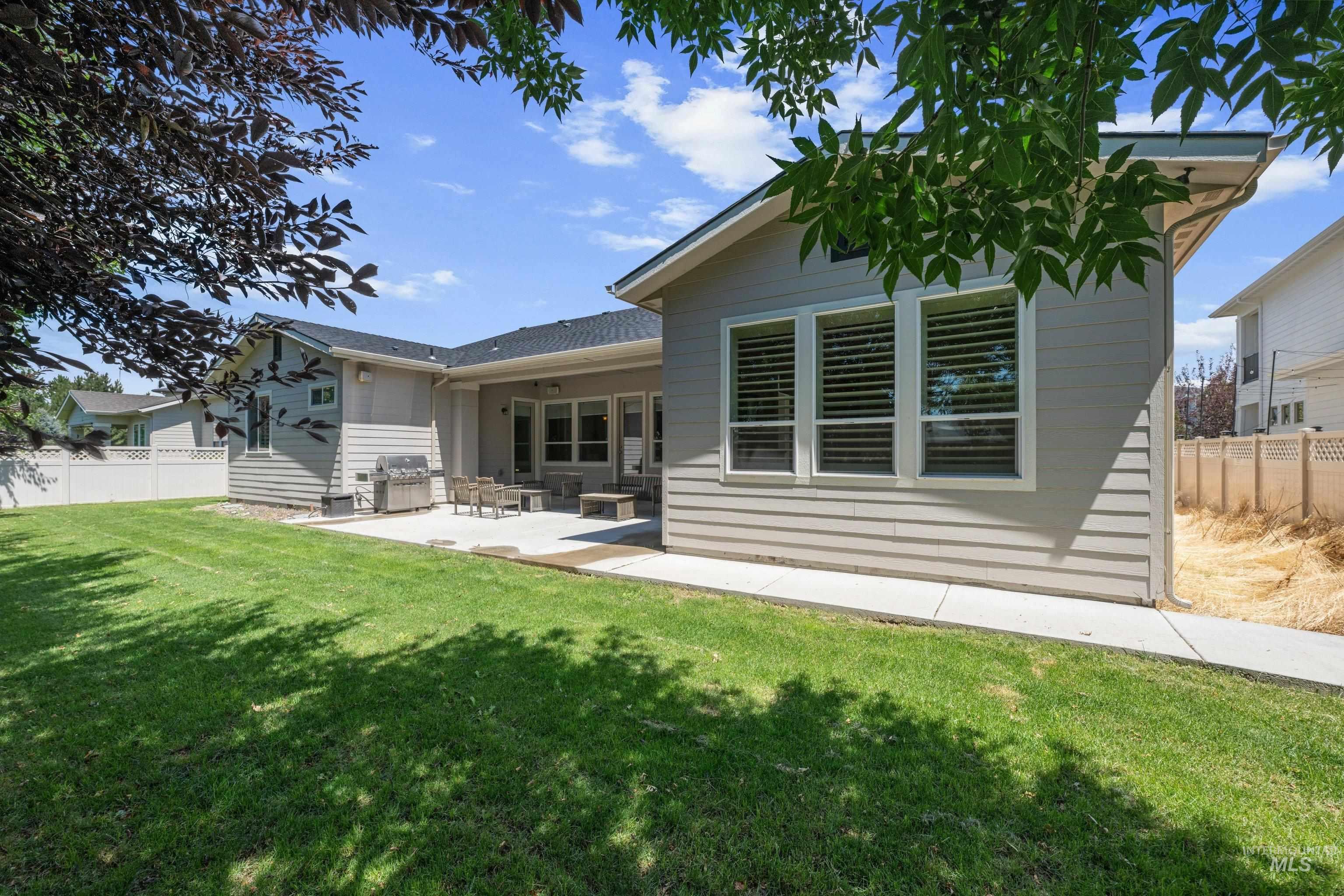 Expansive green lawn with a concrete patio