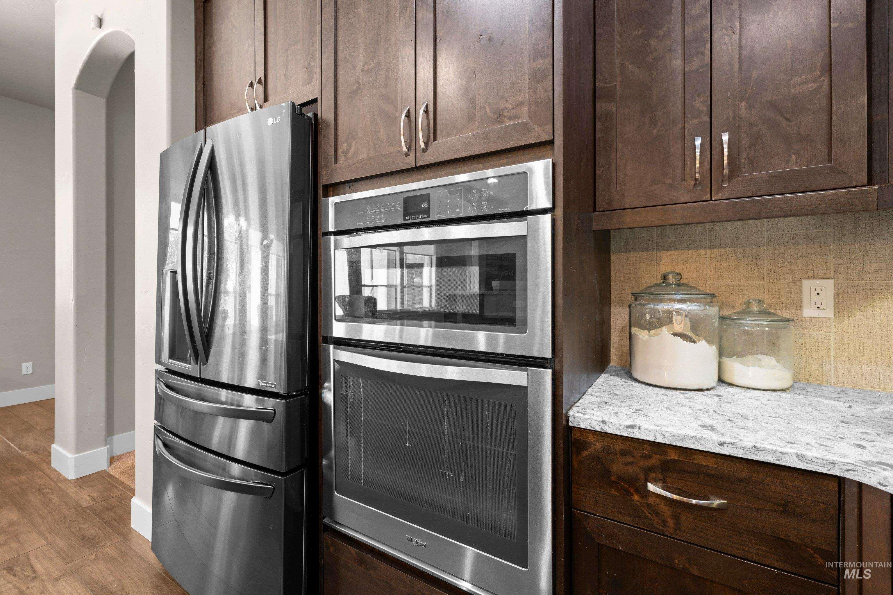Stainless steel appliances featuring a French-door refrigerator, built-in microwave, and wall oven