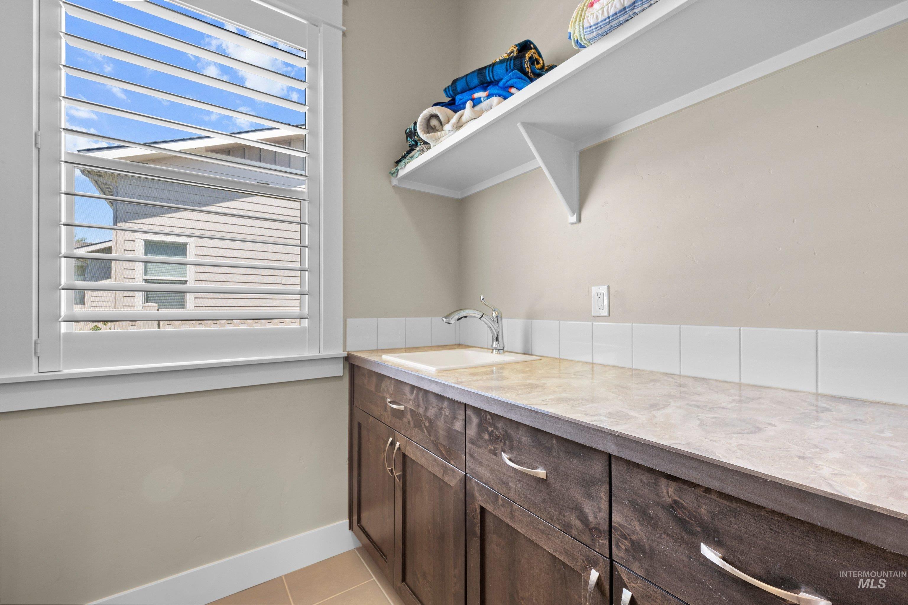 Built-in cabinetry with brushed nickel hardware, a light-toned countertop, and an integrated sink