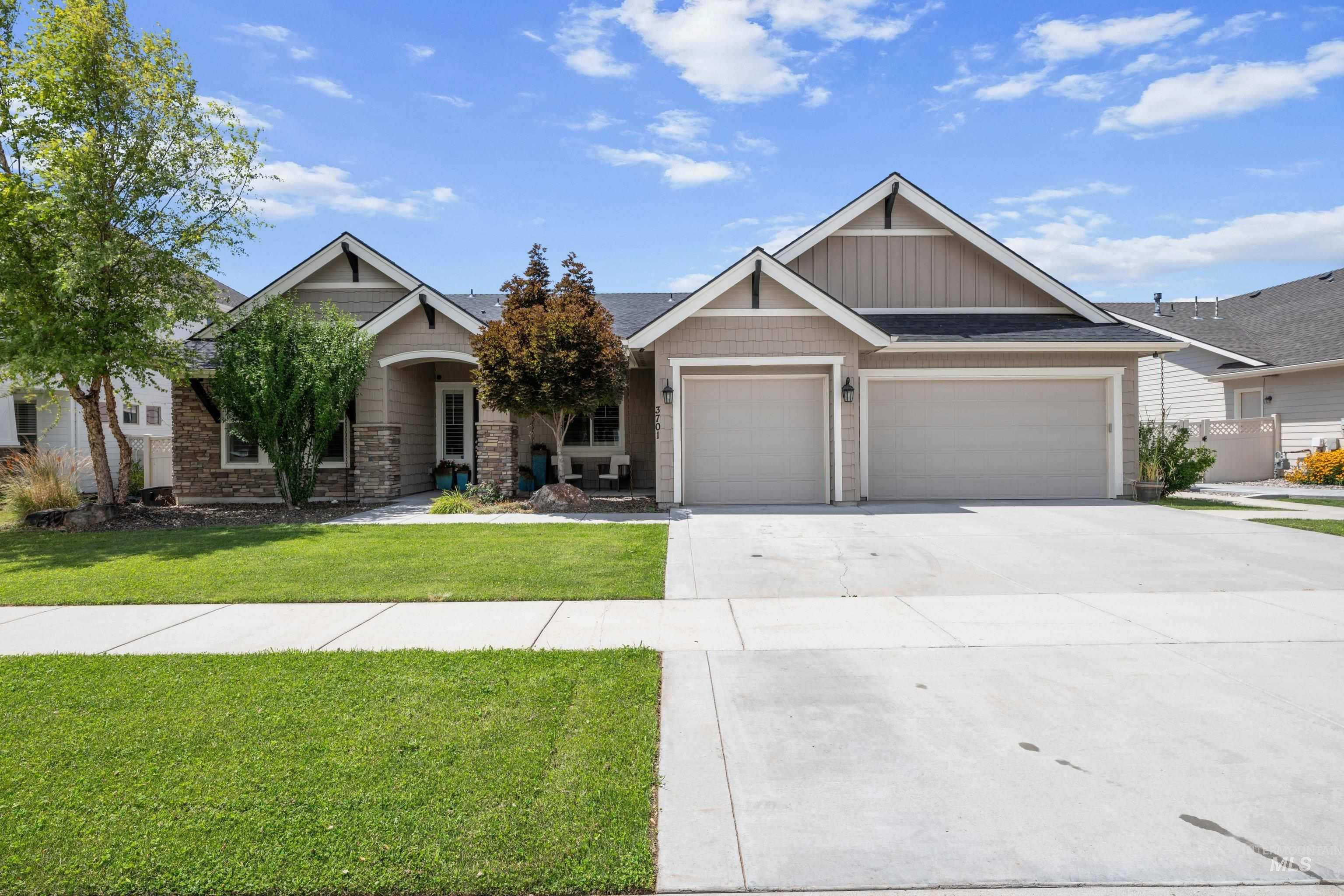 Exterior featuring a two-car garage, stone and siding facade, covered entry, gable rooflines, and a concrete driveway