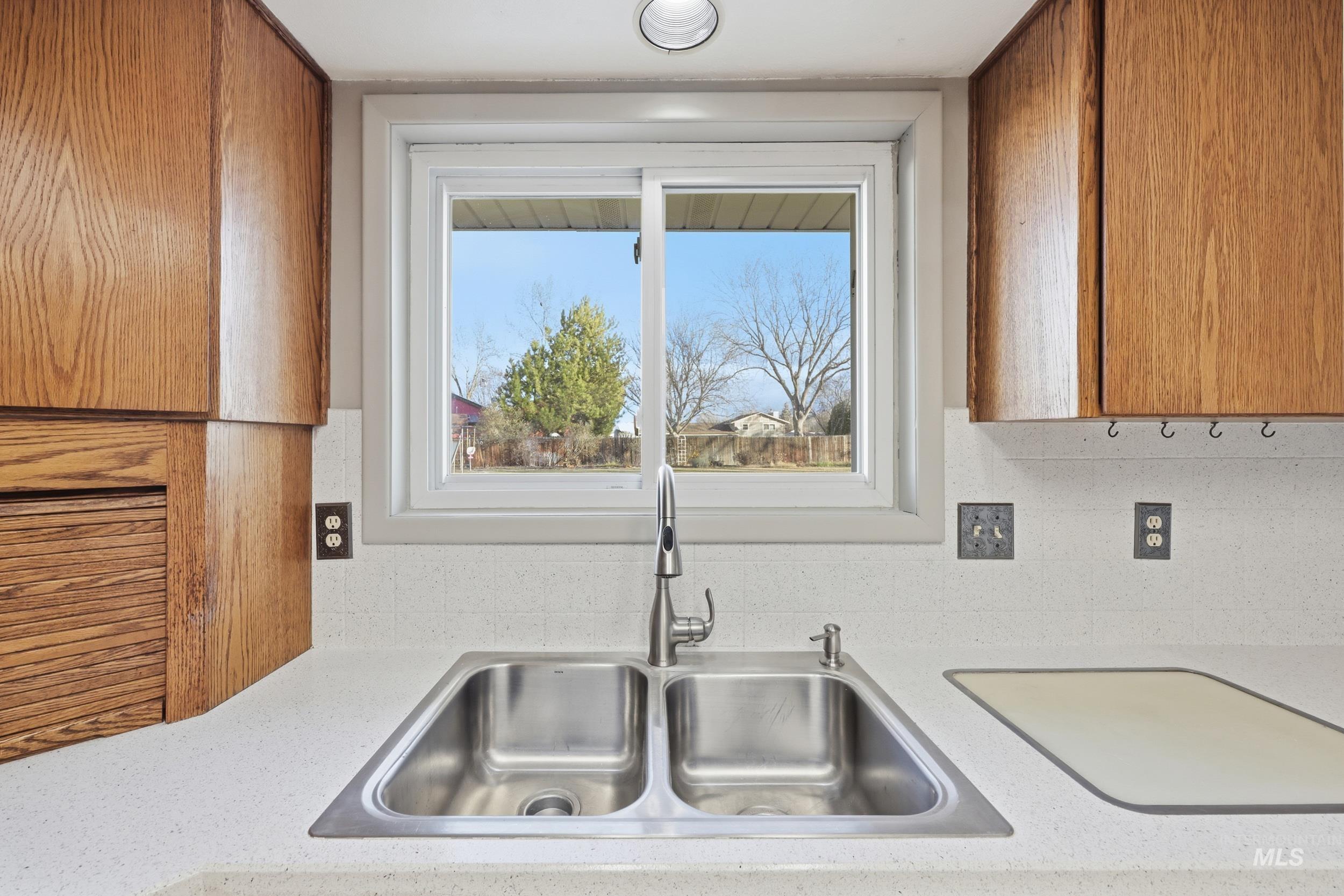 Kitchen with outside view and light hardsurface counters.