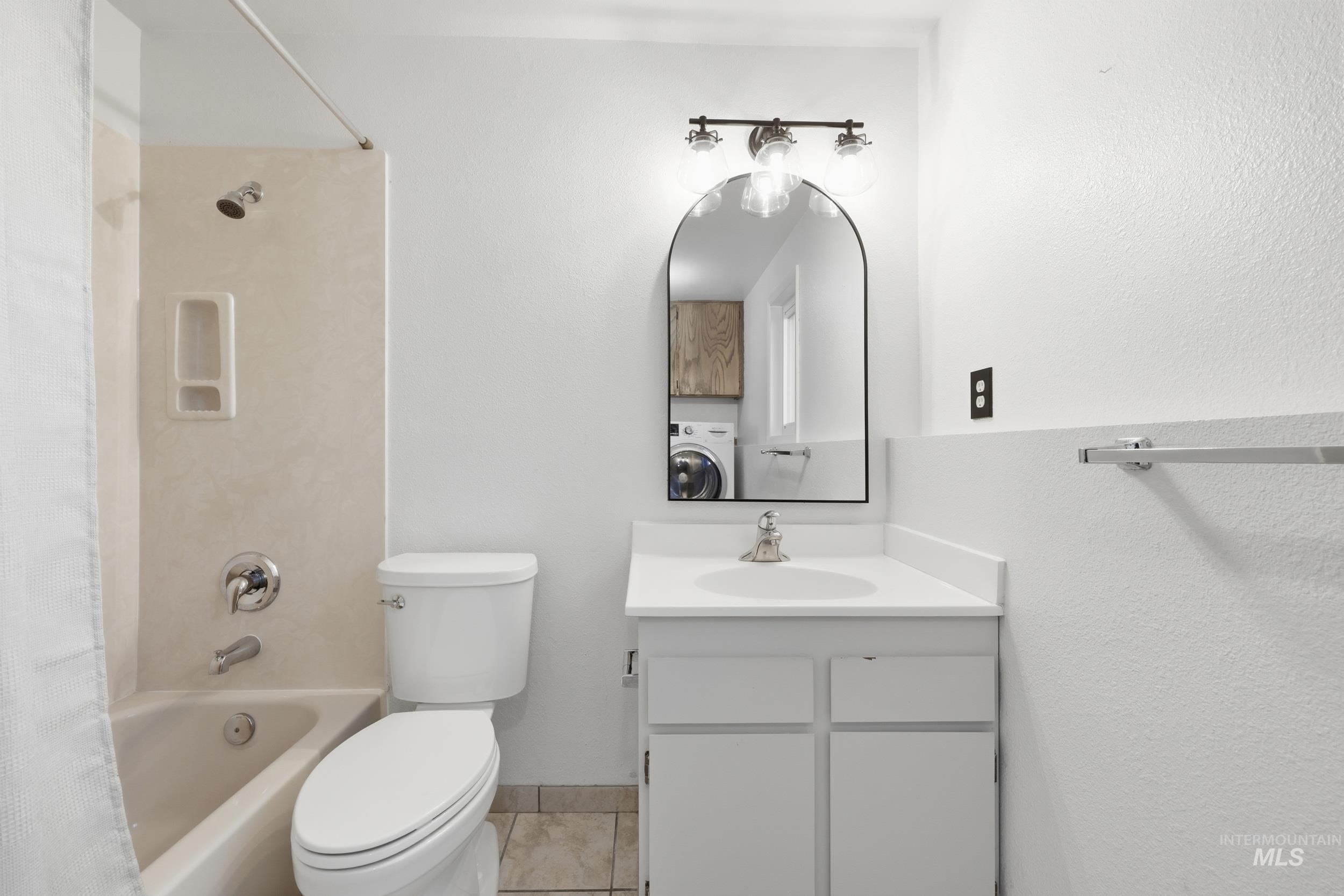 Full downstairs bath featuring shower / tub combo, washer / clothes dryer, and vanity. Perfect for guests.