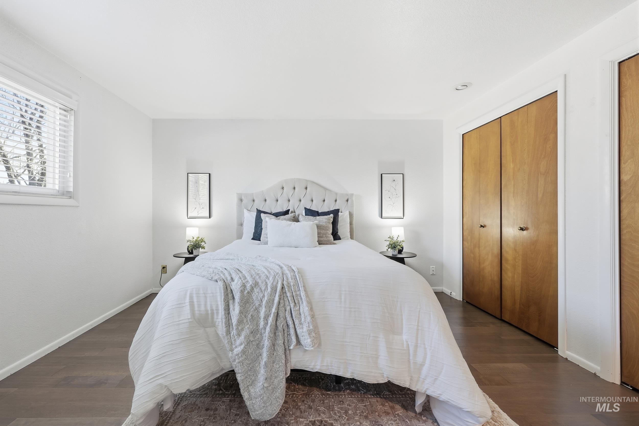 Master bedroom featuring new enginered wood flooring and multiple closet spaces.