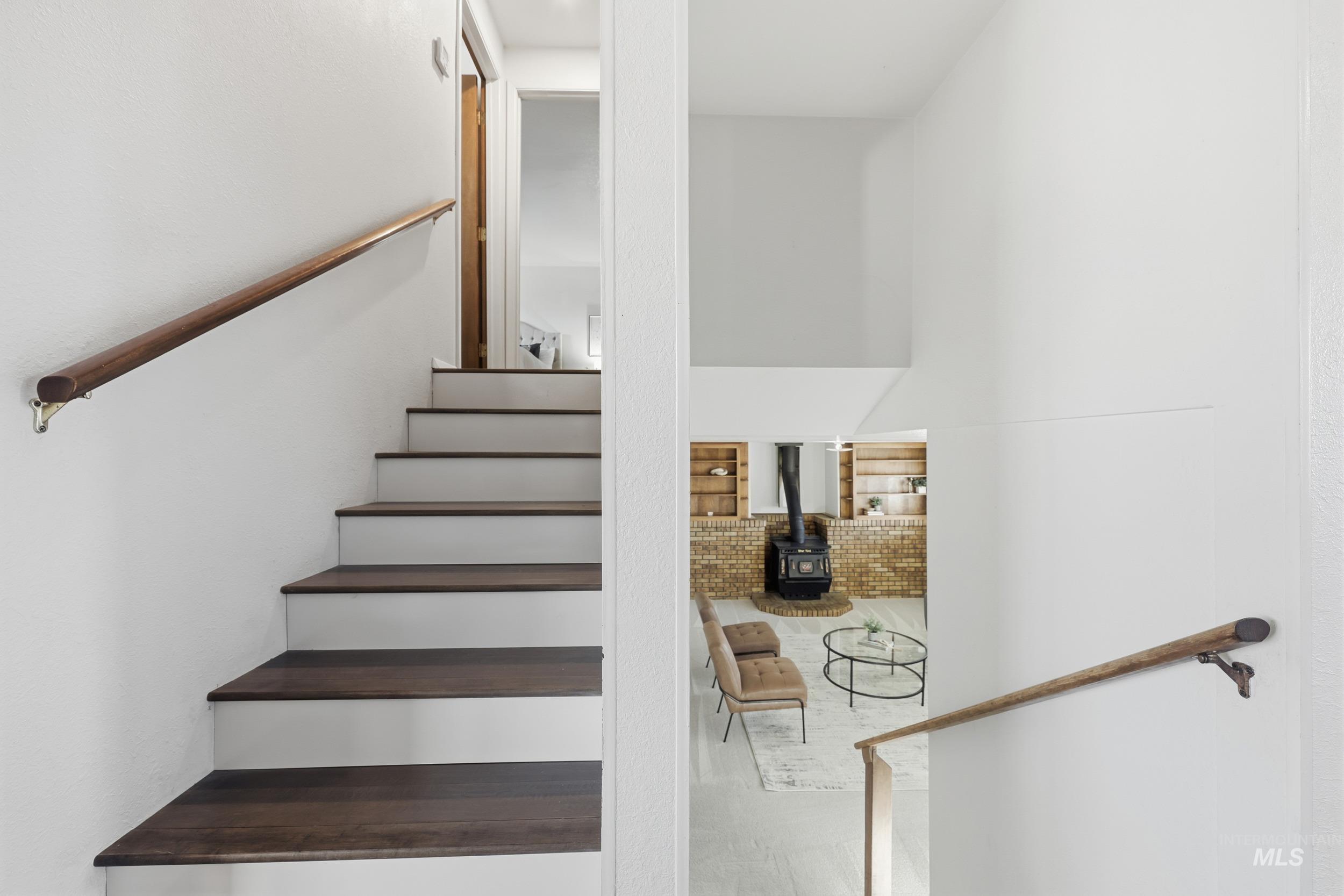 Staircase featuring a wood stove downstairs which is perfect for guests.
