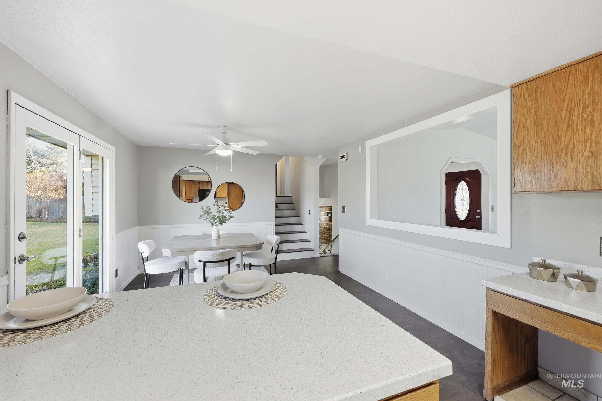 Dining space with wainscoting, new engineered-wood floors, and patio access.